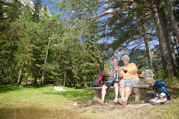 barefoot seniors at lake under conifers