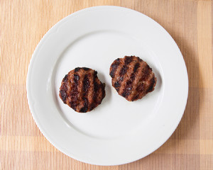Two meatballs on white plate.