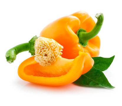 fresh orange peppers with cut and green leaves