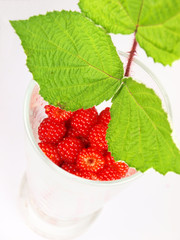 Raspberries in a glass on a white background