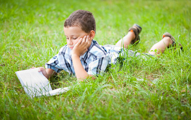 Cute kid reading a book outdoor