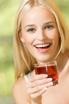 Happy young woman with glass of garnet juice