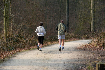 Middle aged couple jogging in a park.