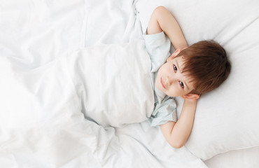 Obraz na płótnie Canvas The little boy on a bed