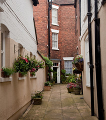Narrow alley leading to red brick house
