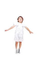 Happy little child in white clothes is jumping isolated