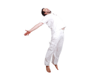 Obraz premium Happy young male in white clothes is jumping isolated