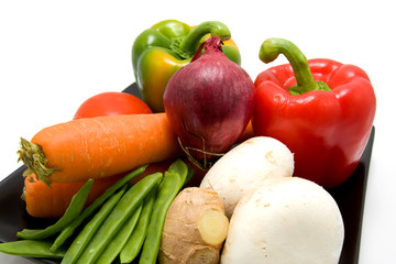 Plate with vegetables on white background