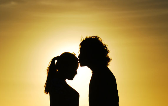 loving couple silhouette kissing at sunset