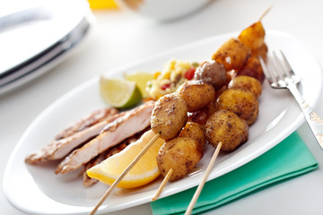 Crispy potatoes with a skewer of chicken steak