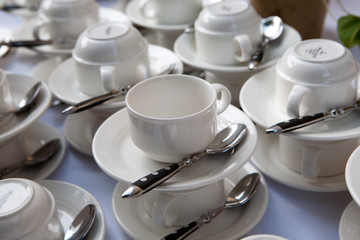 Obraz na płótnie Canvas weiße Kaffetassen auf einem Tisch mit Löffel und Untertasse