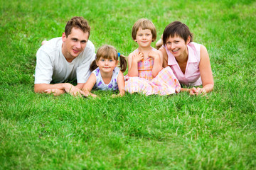 Fototapeta premium Family lying on grass