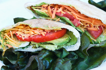 Stuffed pita bread sandwiches on a bed of lettuce.