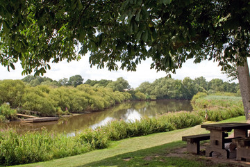 Idyllische Flusslandschaft mit Bank und Personenf&auml;hre