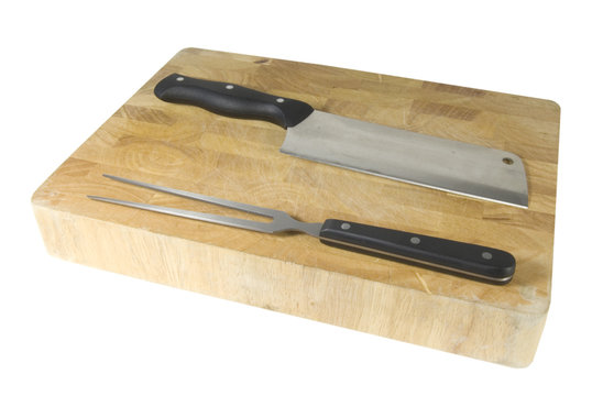 fork and meat cleaver laying level on chopping board on white