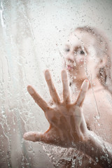 showering woman shot from behind glass