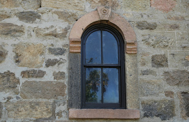 Fototapeta na wymiar Arched Window in Stone Wall