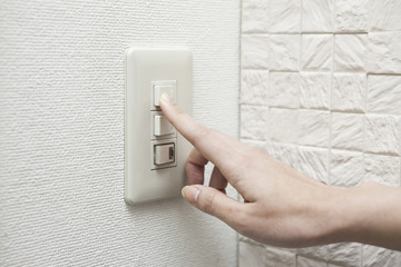 電気をつける女性