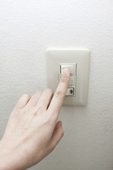 電気をつける女性