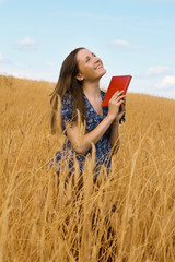 woman with a book in cereals field