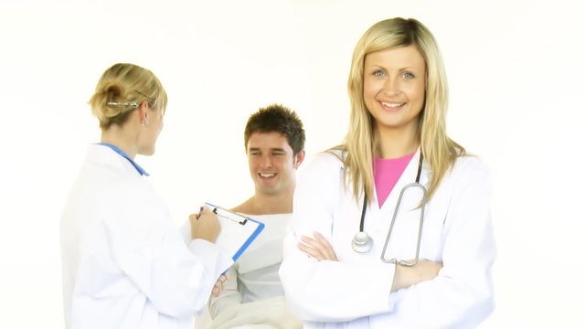 Female doctors smiling at the camera and a male patient