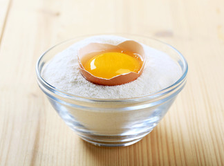 Fresh egg in a bowl of flour
