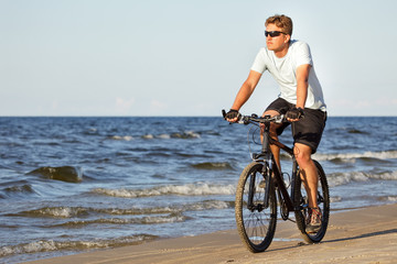 Man riding bicycle in beach