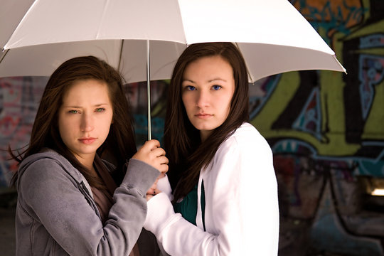 Two Teenage Girls Under a White Umbrella