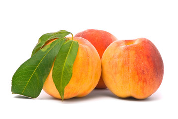 Peach fruits with green leafs isolated on white background