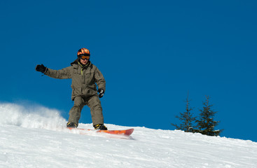 Fototapeta na wymiar Snowboarder riding down the hill
