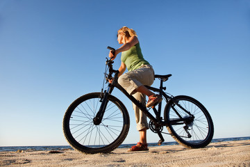 Naklejka premium Young woman with bicycle