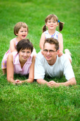 Fototapeta premium Family outdoors lying on grass