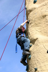 Fototapeta premium Kind klettert an Kletterwand