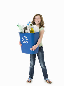 Pretty young girl holding blue recycle bin on white background
