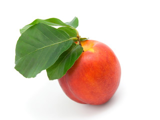 Ripe peach with leaves on a white background
