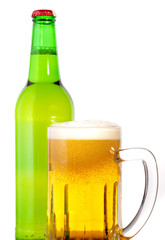 Glass of beer in the front with foam with green bottle of beer