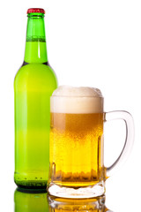 Glass of beer in the front with foam with green bottle of beer
