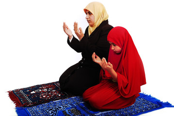 Young muslim female in traditional clothes praying