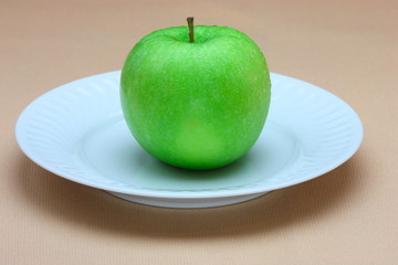 Green apple on white plate