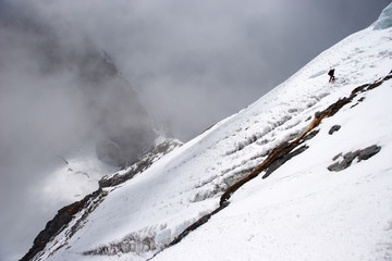 Climber traversing mountain slope at high altitude, Himalayas, Nepal