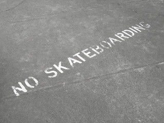 No Skateboarding sign painted on sidewalk