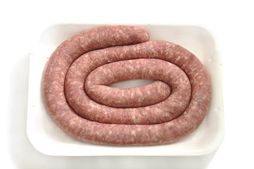 Raw sausage on white tray.