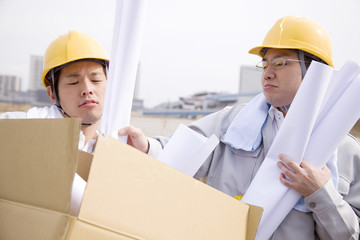 ダンボールに図面を入れる作業員