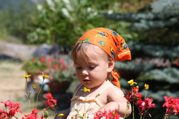 bébé fille touchant des fleurs