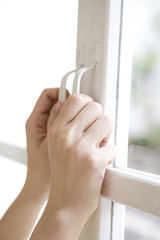 窓を開ける女性の手元