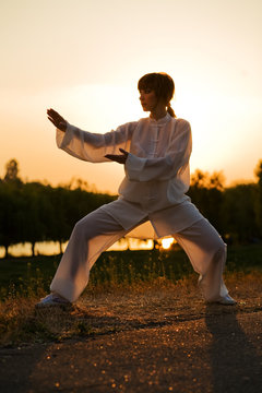 woman in white suit make's taiji chuan exercise - 9