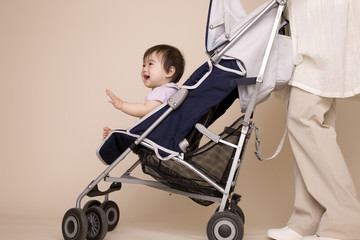 ベビーカーに赤ちゃんを座らせ散歩する母親