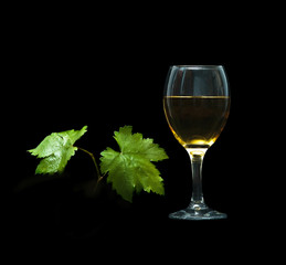 Goblet with wine and grapevine isolated on black background