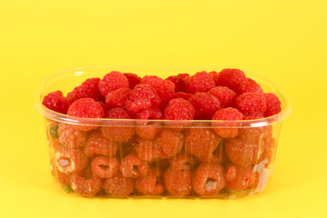 Fresh raspberries in plastic container