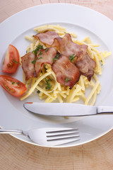 Pasta with tomato and bacon on a plate